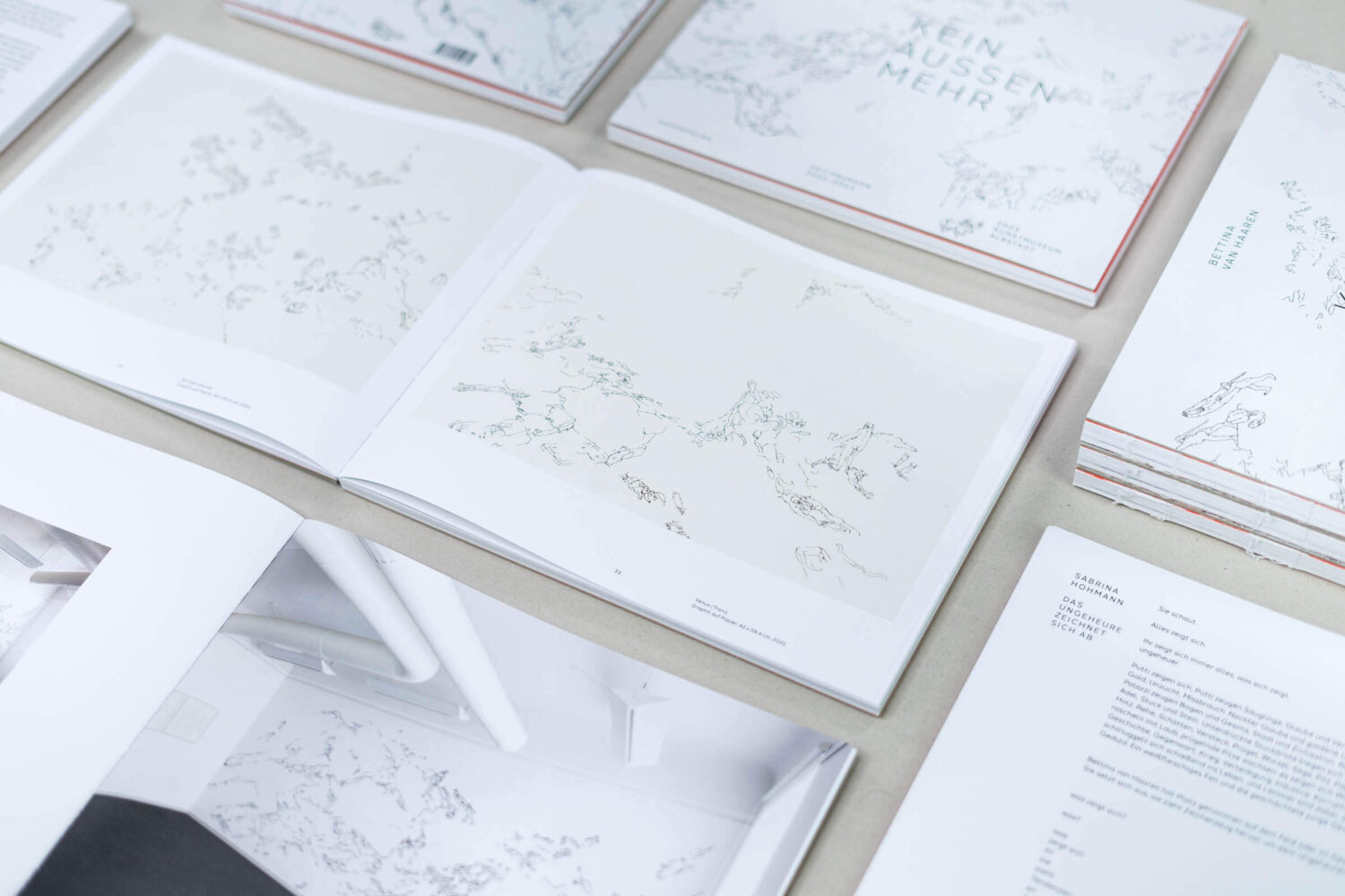 Übersicht über mehrere aufgeschlagene Ausstellungskataloge.